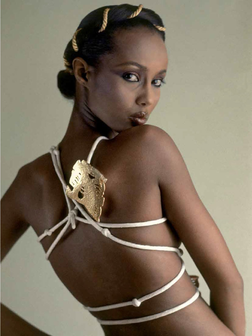 Model, Iman, with body wrapping of silk cording anchored with a huge golden jewel.
